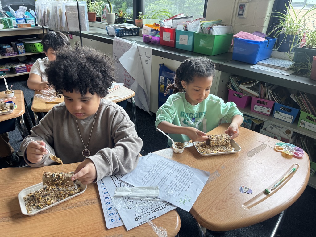 First graders in Mrs. Bowen's class make bird feeders with recycled materials.