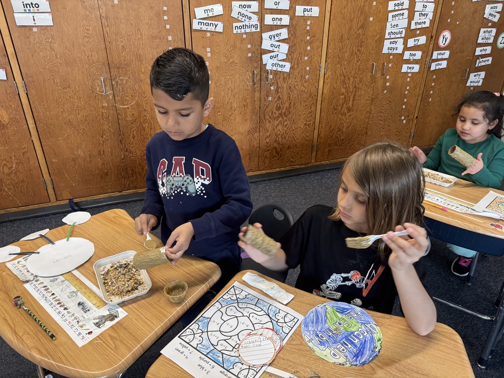 First graders in Mrs. Bowen's class make bird feeders with recycled materials.