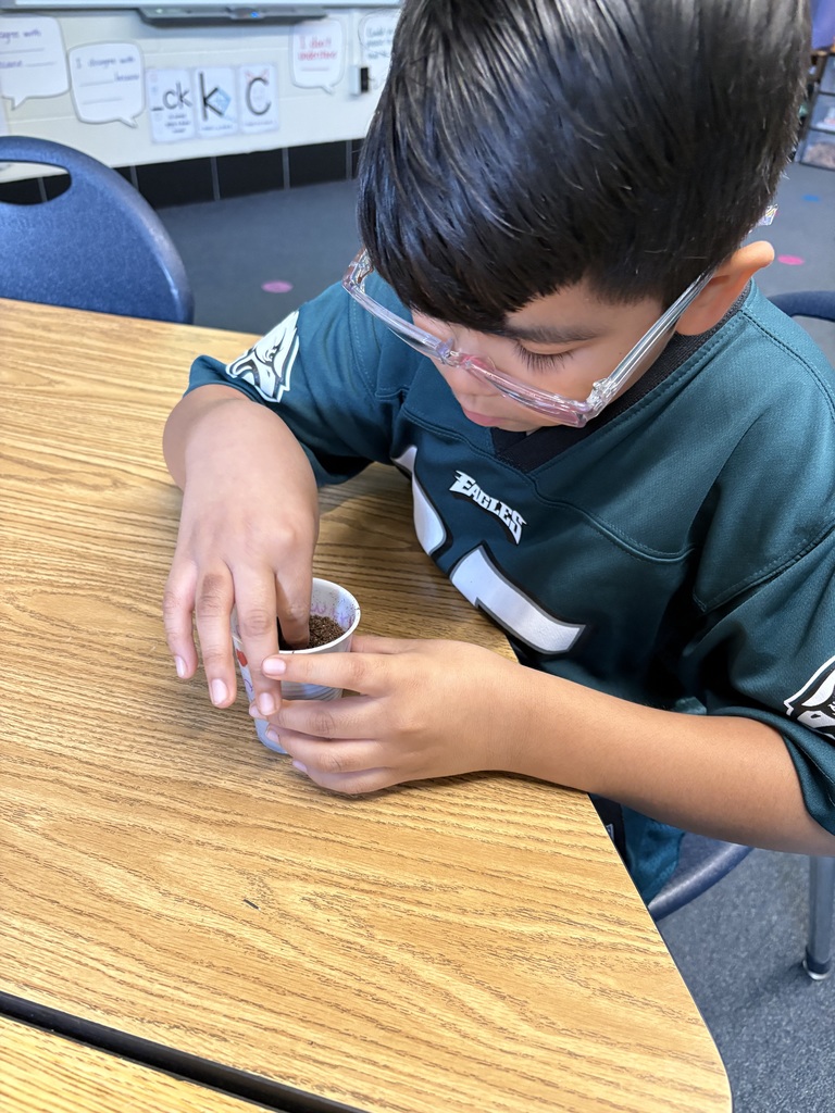 A second grader planting seeds on Earth Day.