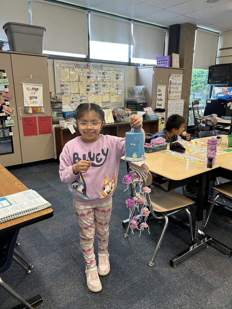 A student shows her project made of recycled materials.