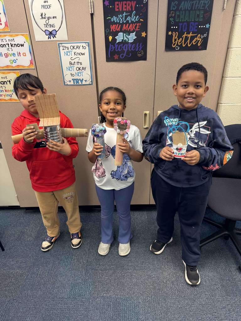 Students show their projects made of recycled materials.