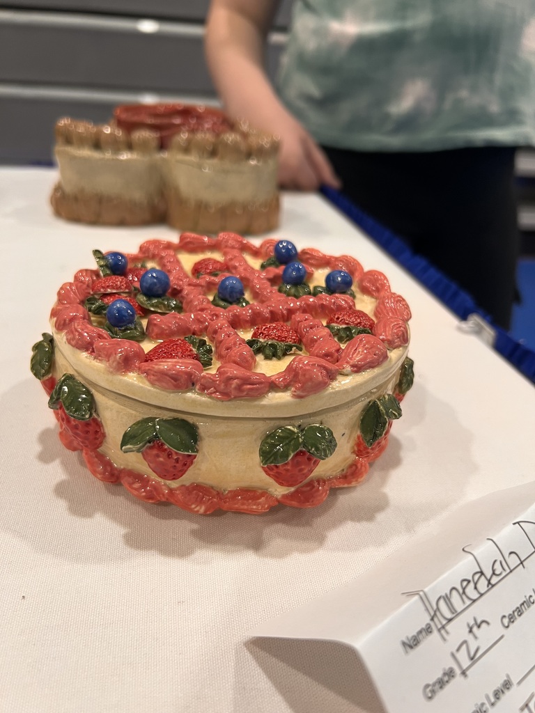 A student ceramic project that is in the shape of a pie is on display