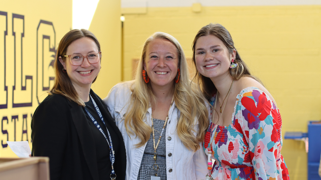 Three teachers pose for a photo together. 