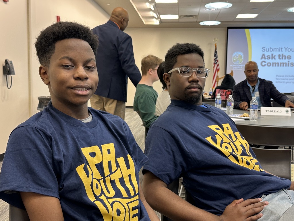Two students are sitting together wearing their PA youth vote shirts