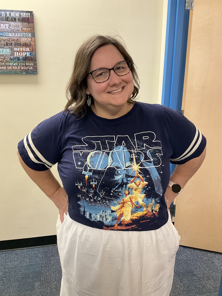 A teacher is posing with her starwars gear.