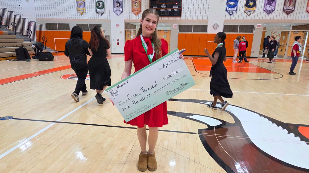 Emma holding giant scholarship check.