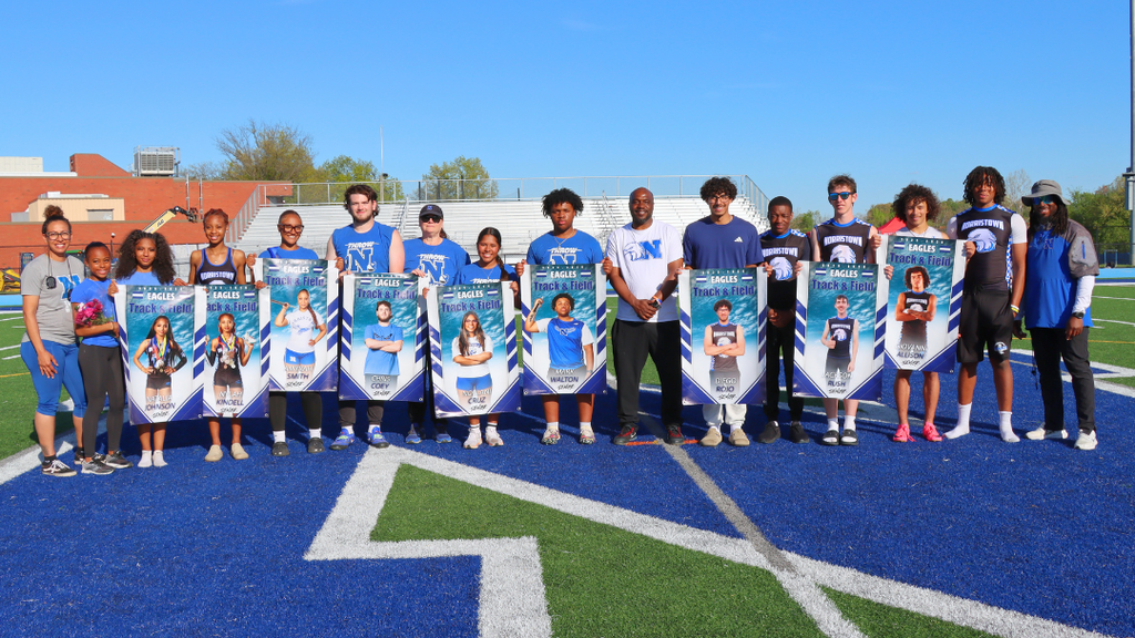 Seniors from the track and field team pose with coaches for large group photo.