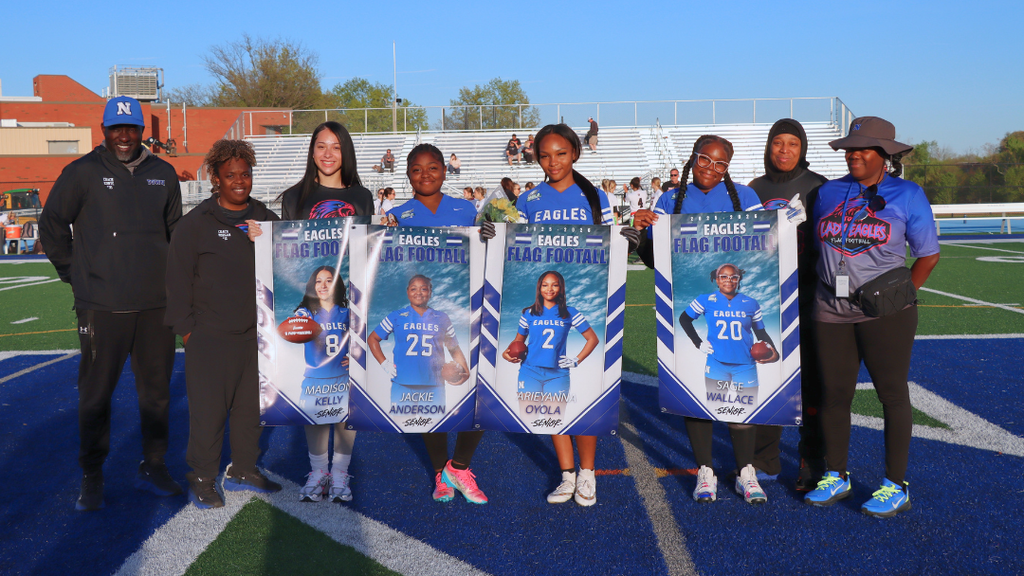 Seniors from the flag football team pose with coaches for group photo.