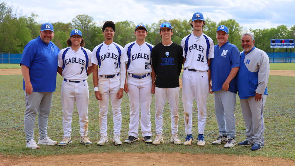 Seniors from the baseball team pose with coaches for group photo.