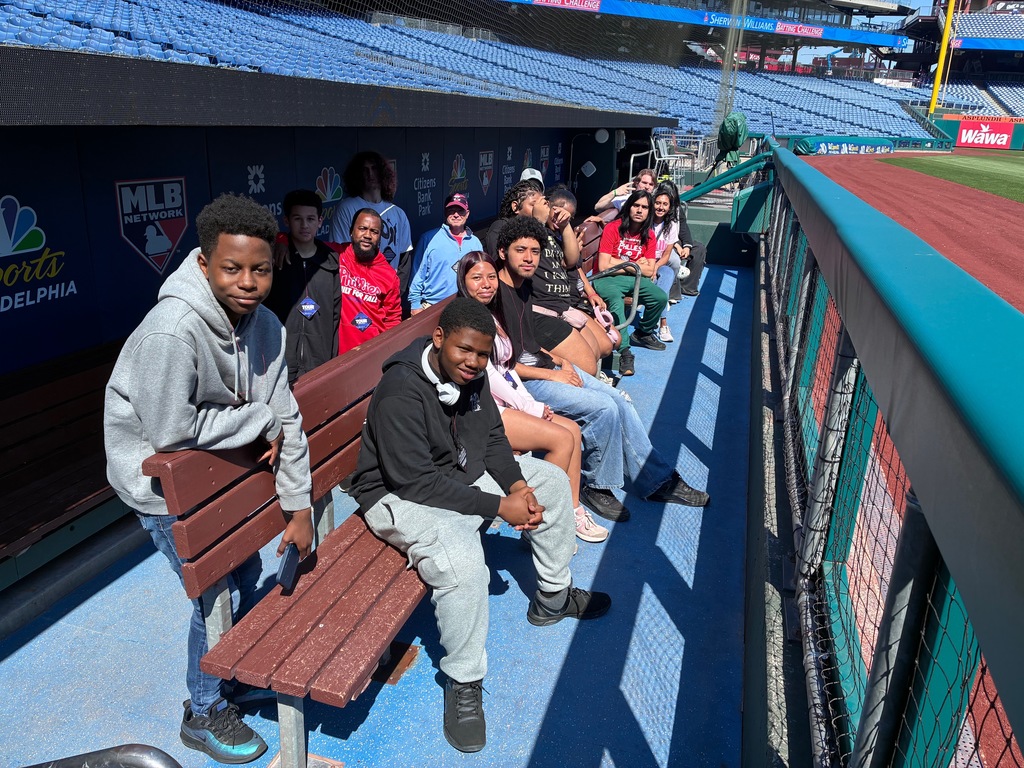 A group of students are sitting in the Phillies dugout