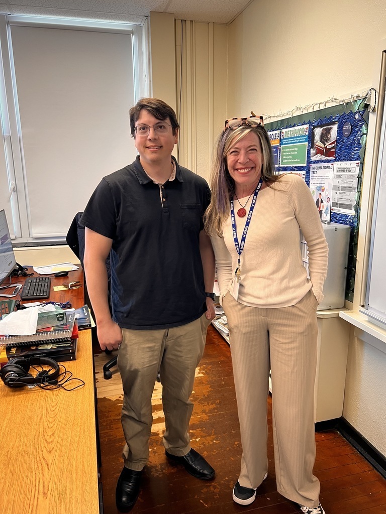 The two English teachers are posing in a classroom together
