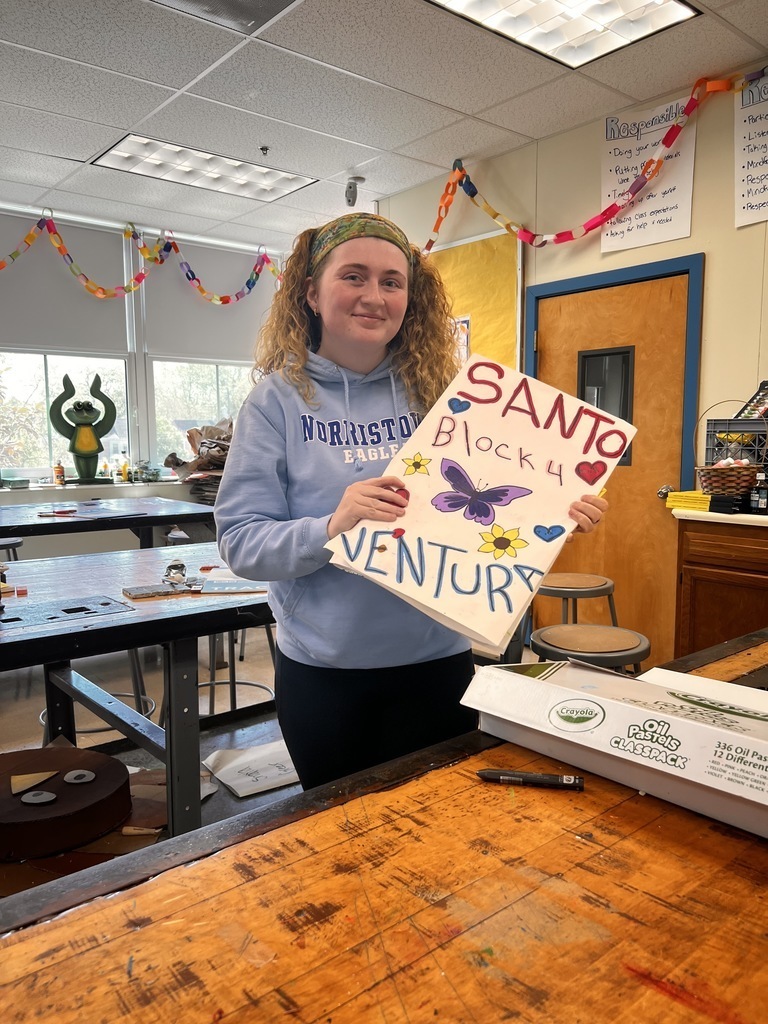 The art teacher is holding some artwork