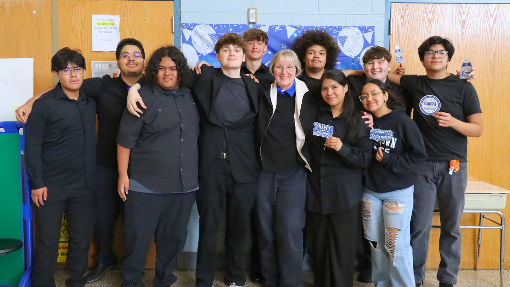 Retiree poses with group of students at the retirement celebration.