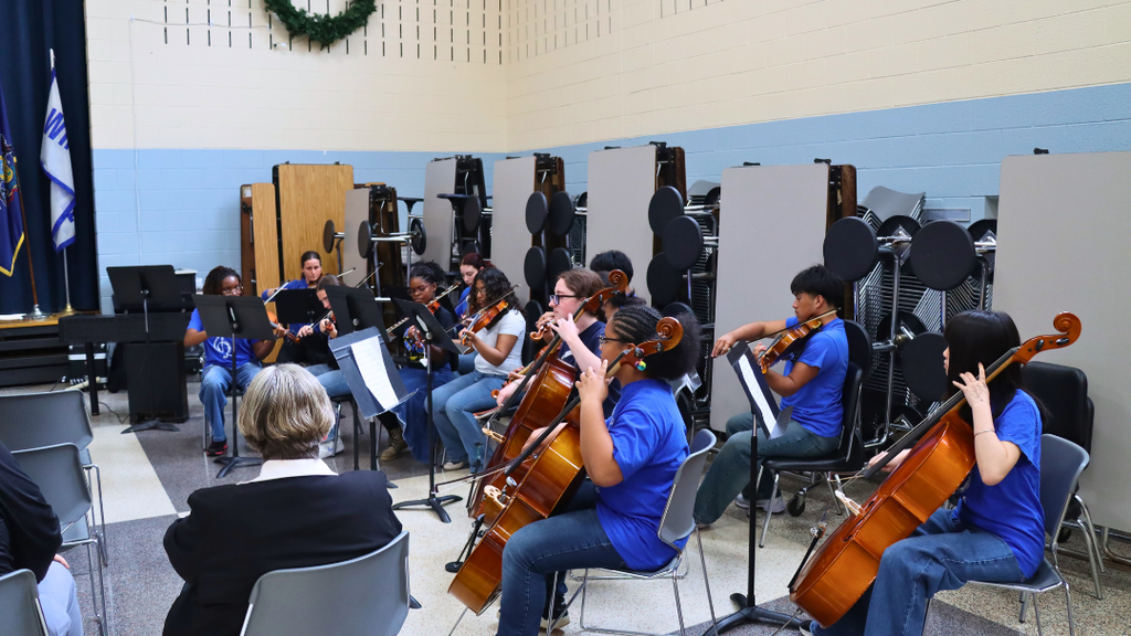 NAHS studnets playing string instruments at the retirement celebration.