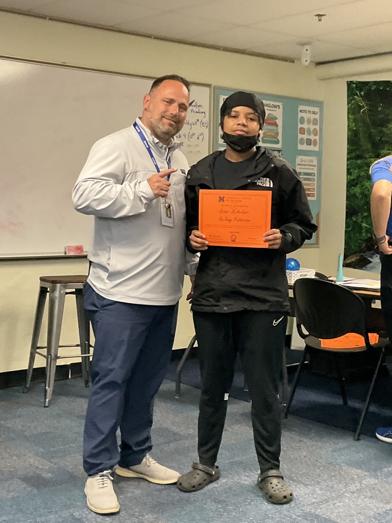 A student and the principal are posing with a certificate