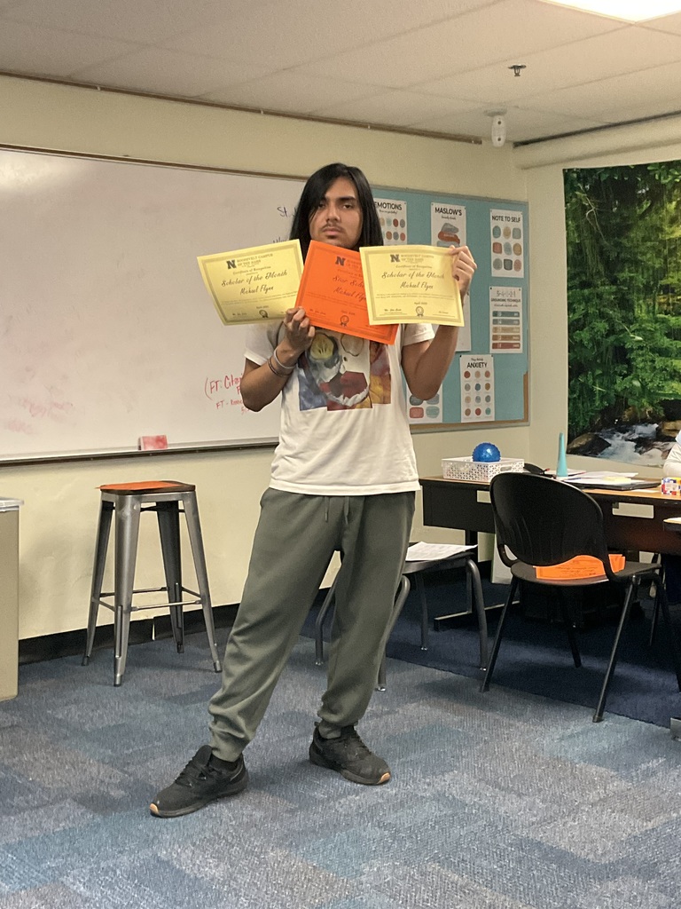 A student is holding 3 awards