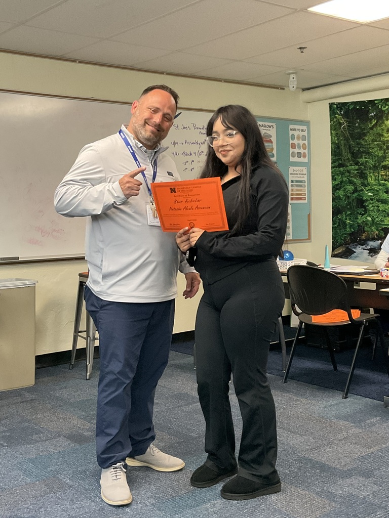 A student is posing with her award