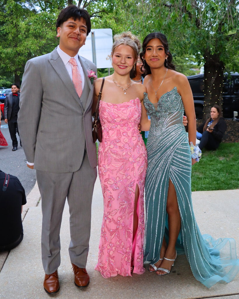 Three students at senior prom pose for photo.