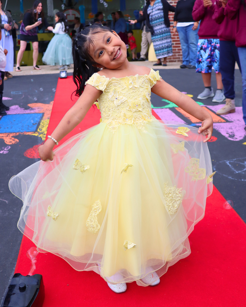 Student poses on red carpet for Kindergarten Prom outside of Musselman Learning Center.