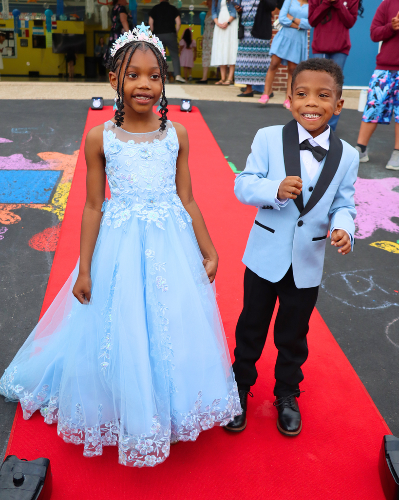 Two students pose on red carpet for Kindergarten Prom outside of Musselman Learning Center.