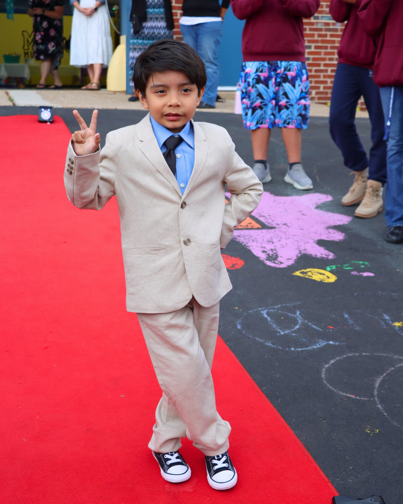 Student poses on red carpet for Kindergarten Prom outside of Musselman Learning Center.