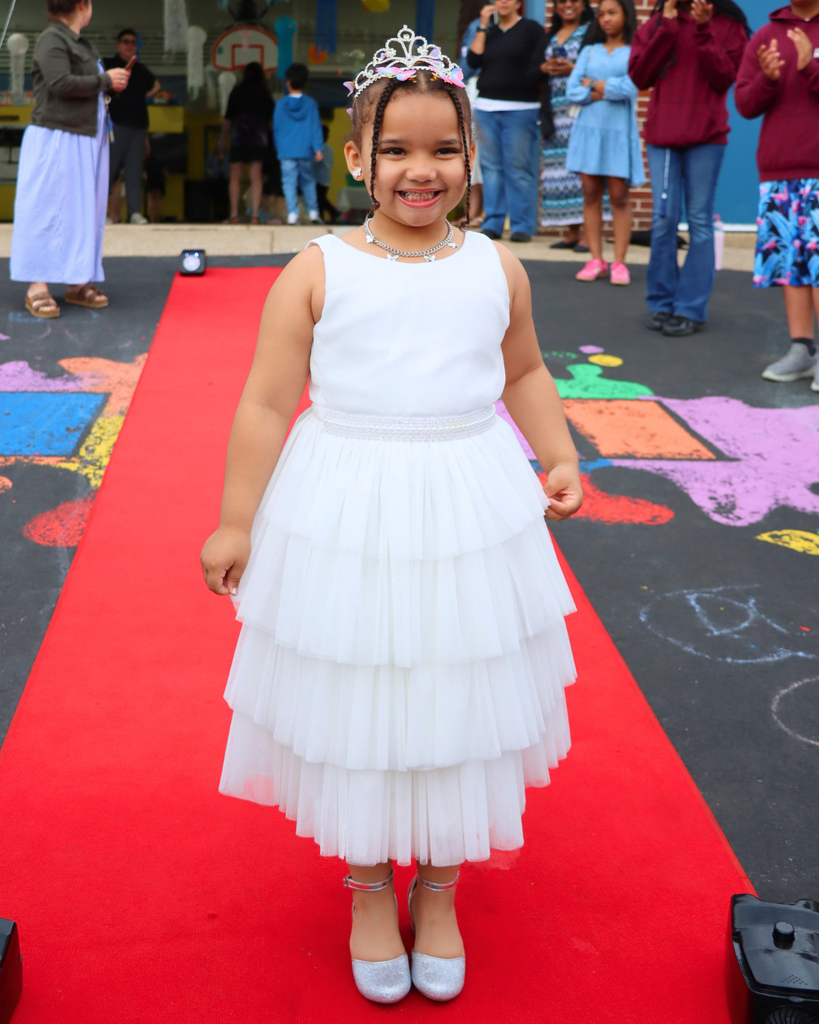 Student poses on red carpet for Kindergarten Prom outside of Musselman Learning Center.