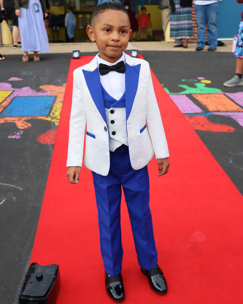 Student poses on red carpet for Kindergarten Prom outside of Musselman Learning Center.