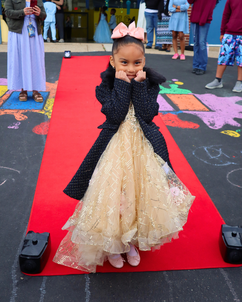 Student poses on red carpet for Kindergarten Prom outside of Musselman Learning Center.