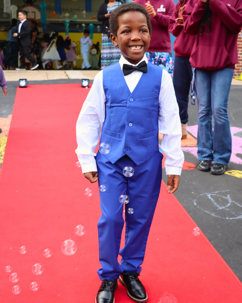 Student poses on red carpet for Kindergarten Prom outside of Musselman Learning Center.