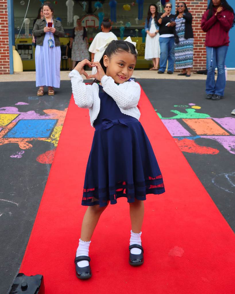 Student poses on red carpet for Kindergarten Prom outside of Musselman Learning Center.