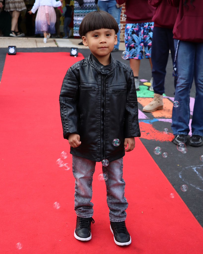 Student poses on red carpet for Kindergarten Prom outside of Musselman Learning Center.