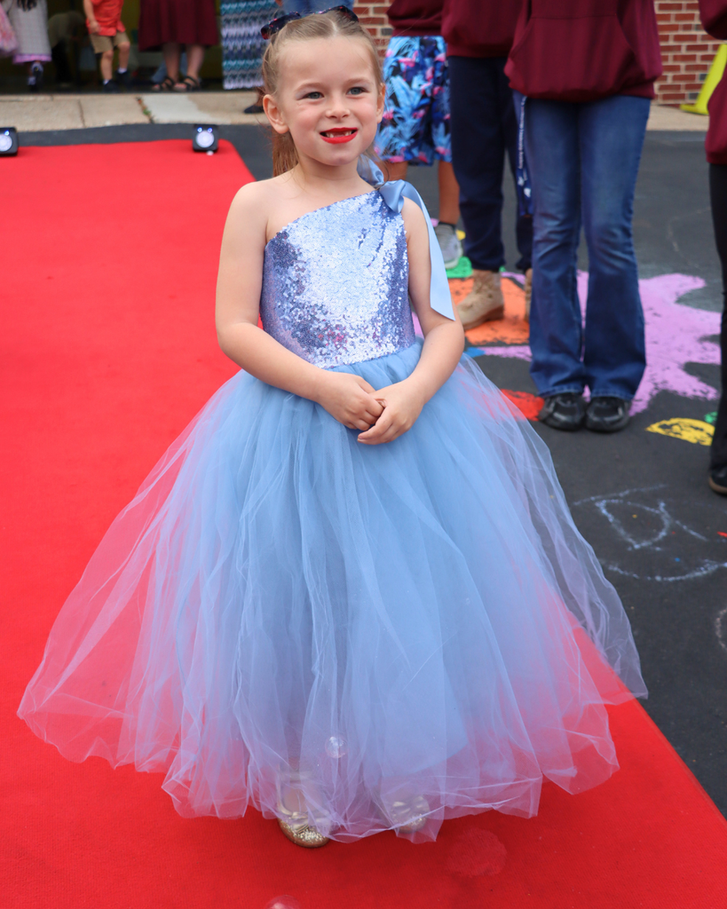Student poses on red carpet for Kindergarten Prom outside of Musselman Learning Center.