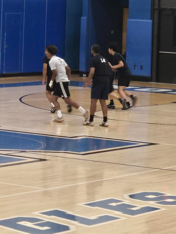 Students are playing soccer on the court in the gym