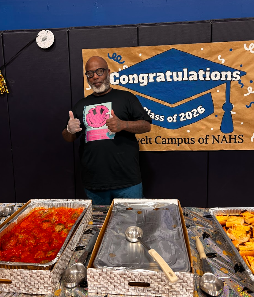 A board member is behind the table giving a thumbs up