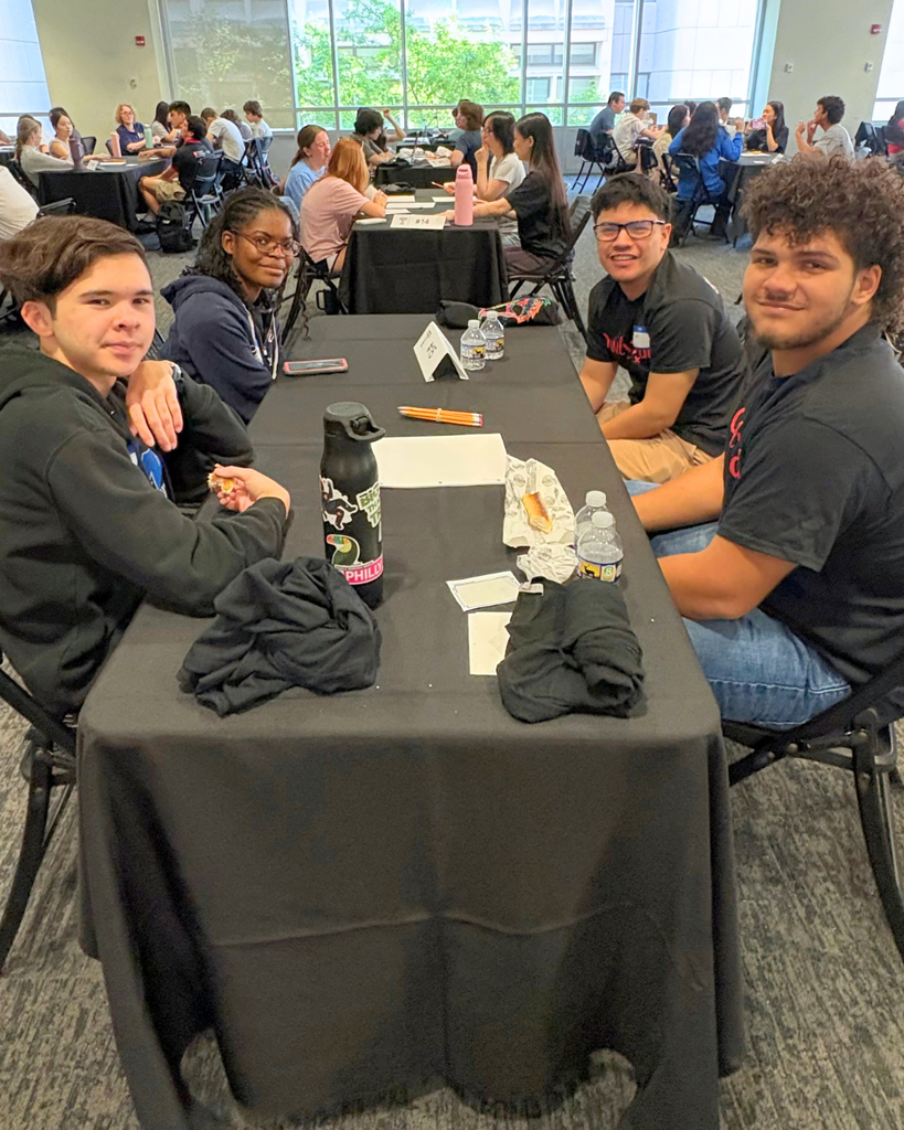 Four studnets sitting at table at Temple University competition.