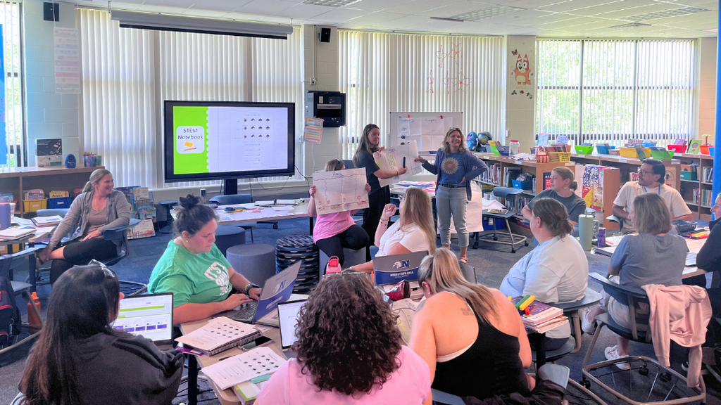 Teachers participating in professional development session presenting their poster board.