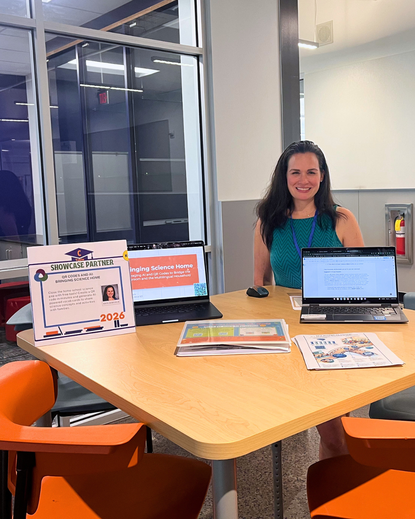 Teacher sitting at a table with her presentation materials.