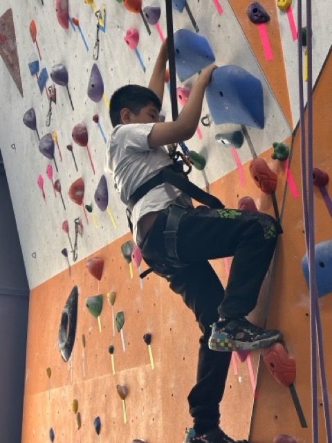A fourth grader climbs a rock wall at the Philadelphia Rock Gym.
