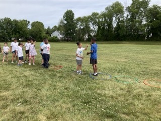 Students play Championship Rock, Paper, Scissors at Field Day.