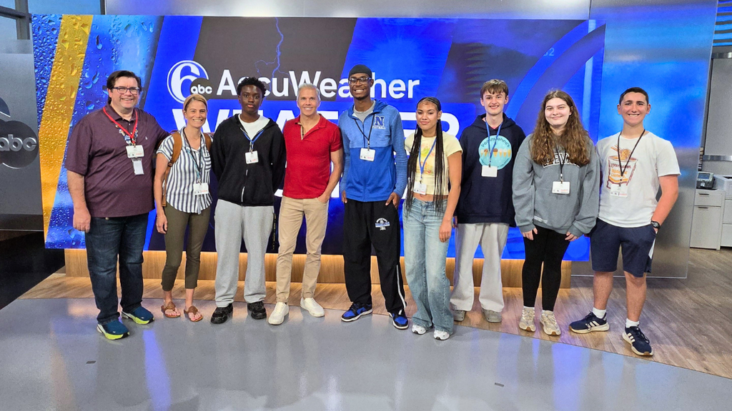 NAHS studnets and teachers pose with meteorologist Adam Joseph in front of 6ABC screen.