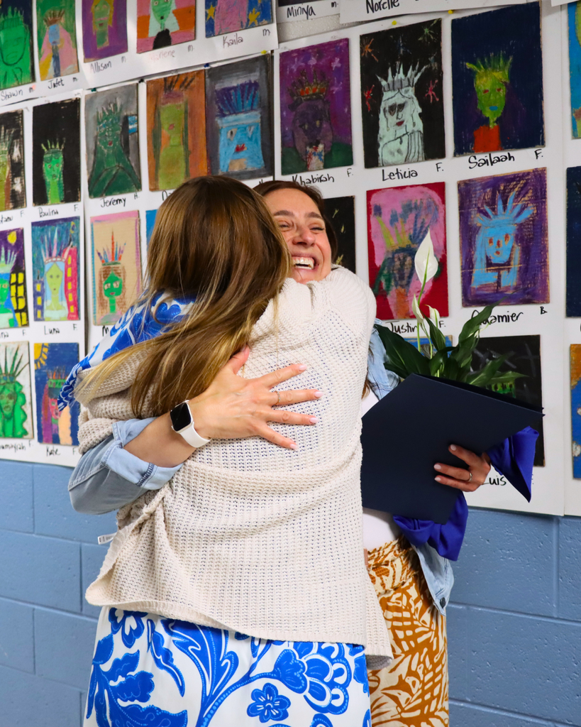 Fellow teacher hugs Mrs. Windheim after the teacher of the year announcement is made.