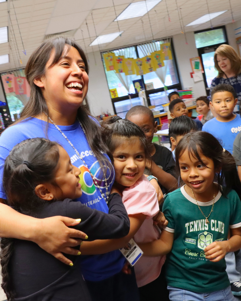 Studnets hugging Ms. Cabrera after teacher of the year announcement.