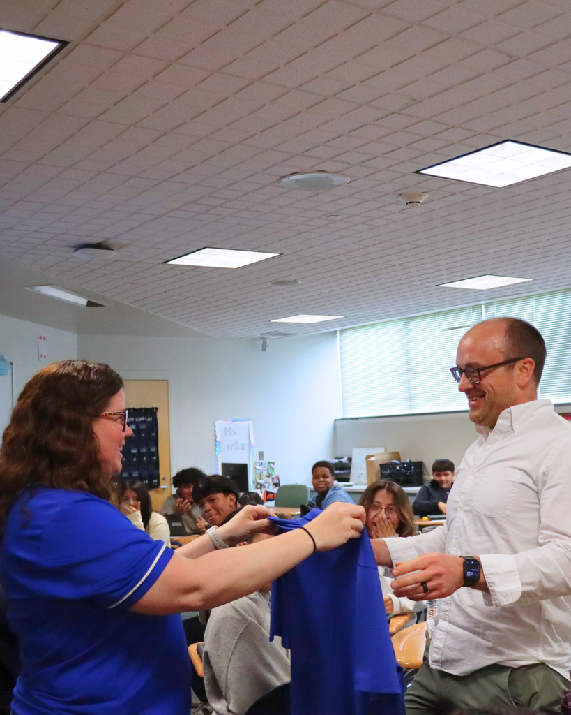 Mr. Humbert being handed his embroidered shirt for teacher of the year.