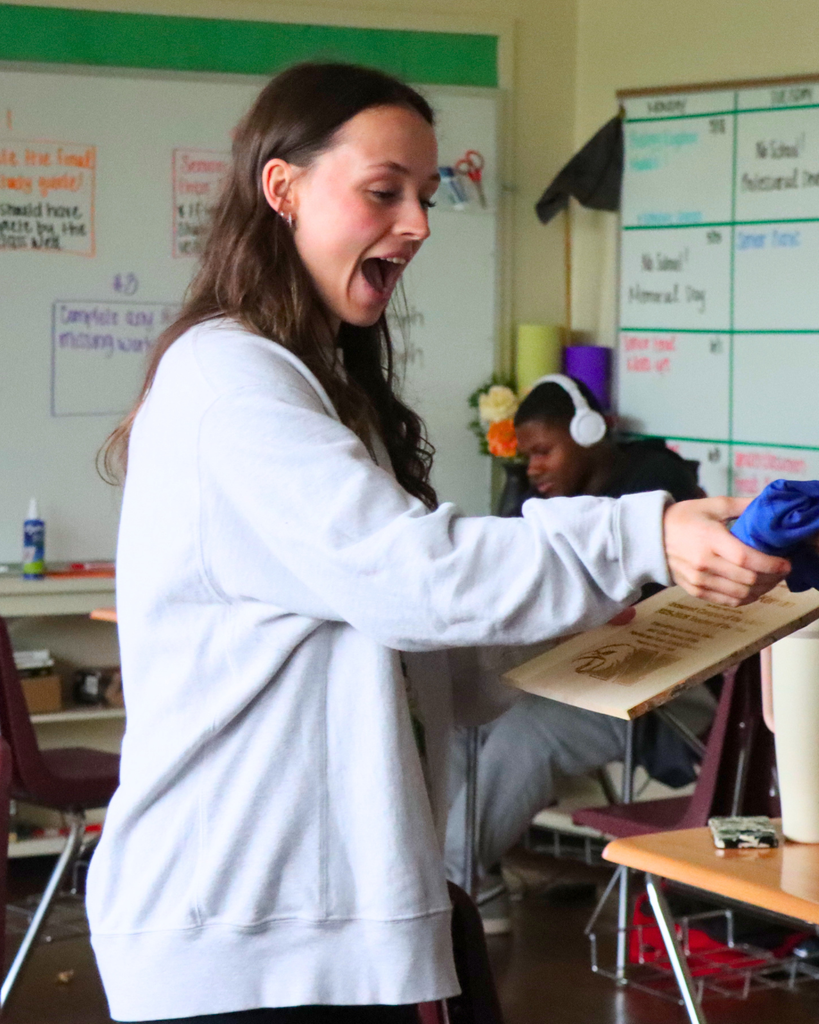 Ms. McKernan surprised as she is handed her plaque and shirt.