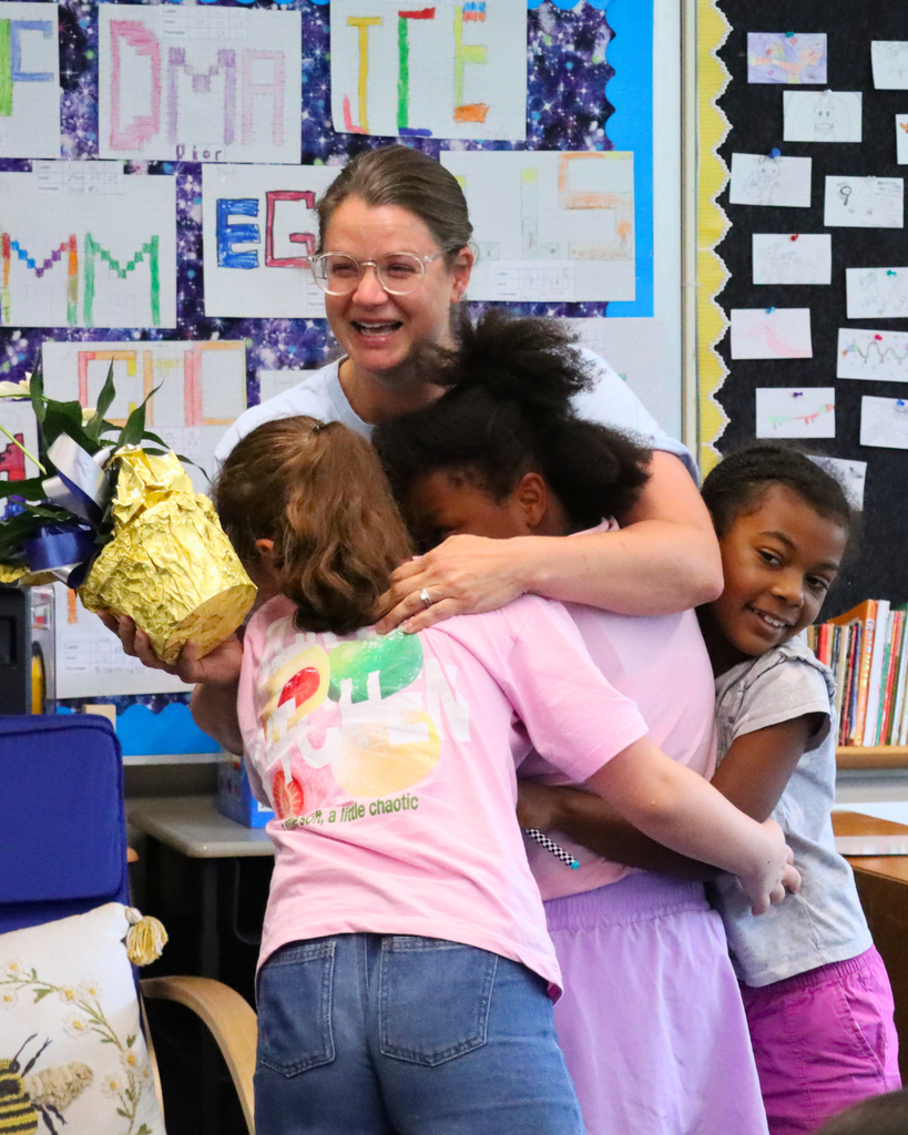 Students hugging Mrs. Shuler in her classroom after teacher of the year announcement.