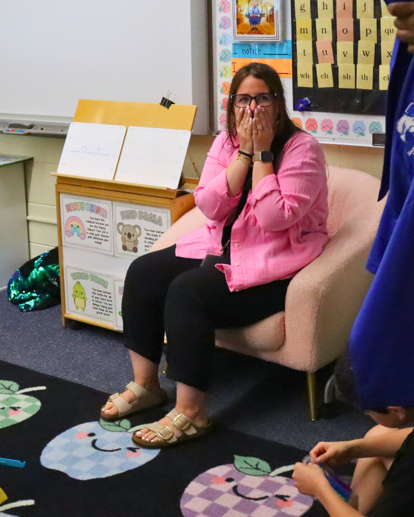 Ms. Gambone's reaction to hearing she is the teacher of the year. She covers her mouth with her hands in surprise.