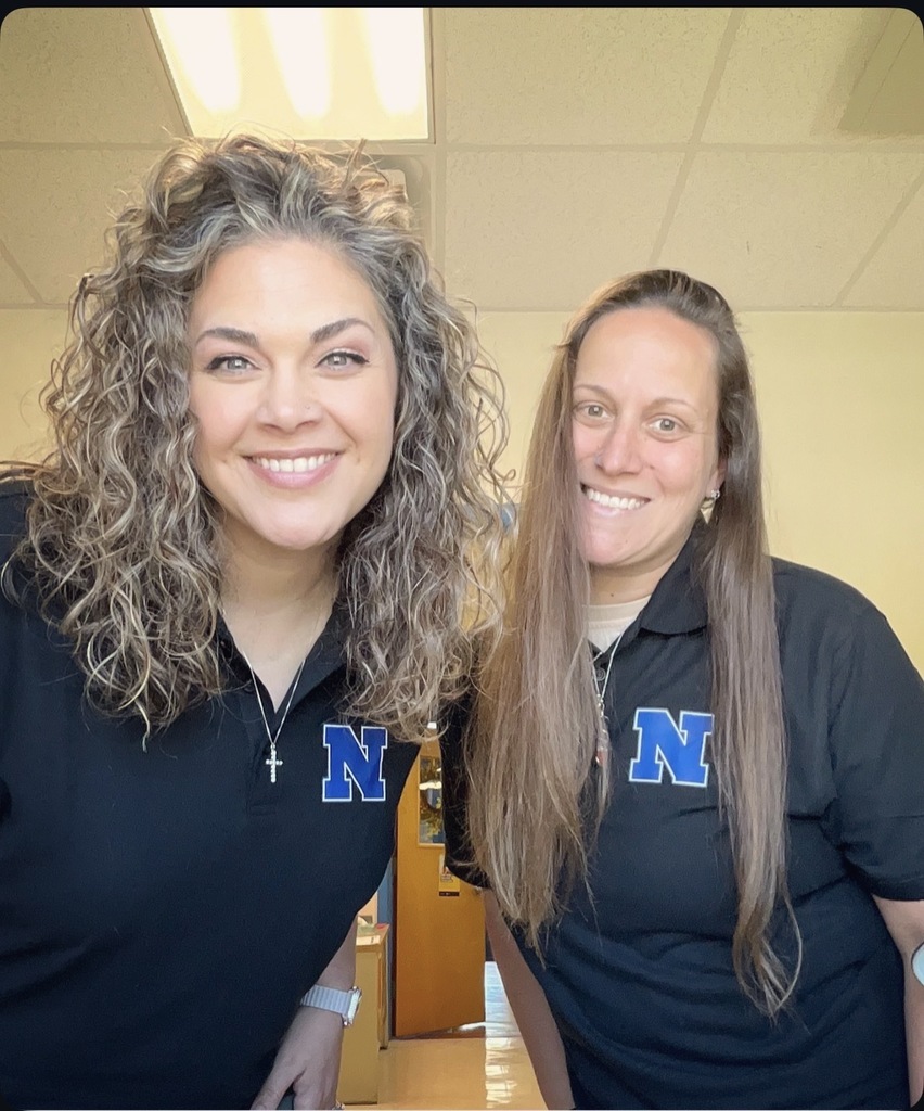 Two teachers are together wearing black shirts and Royal blue N