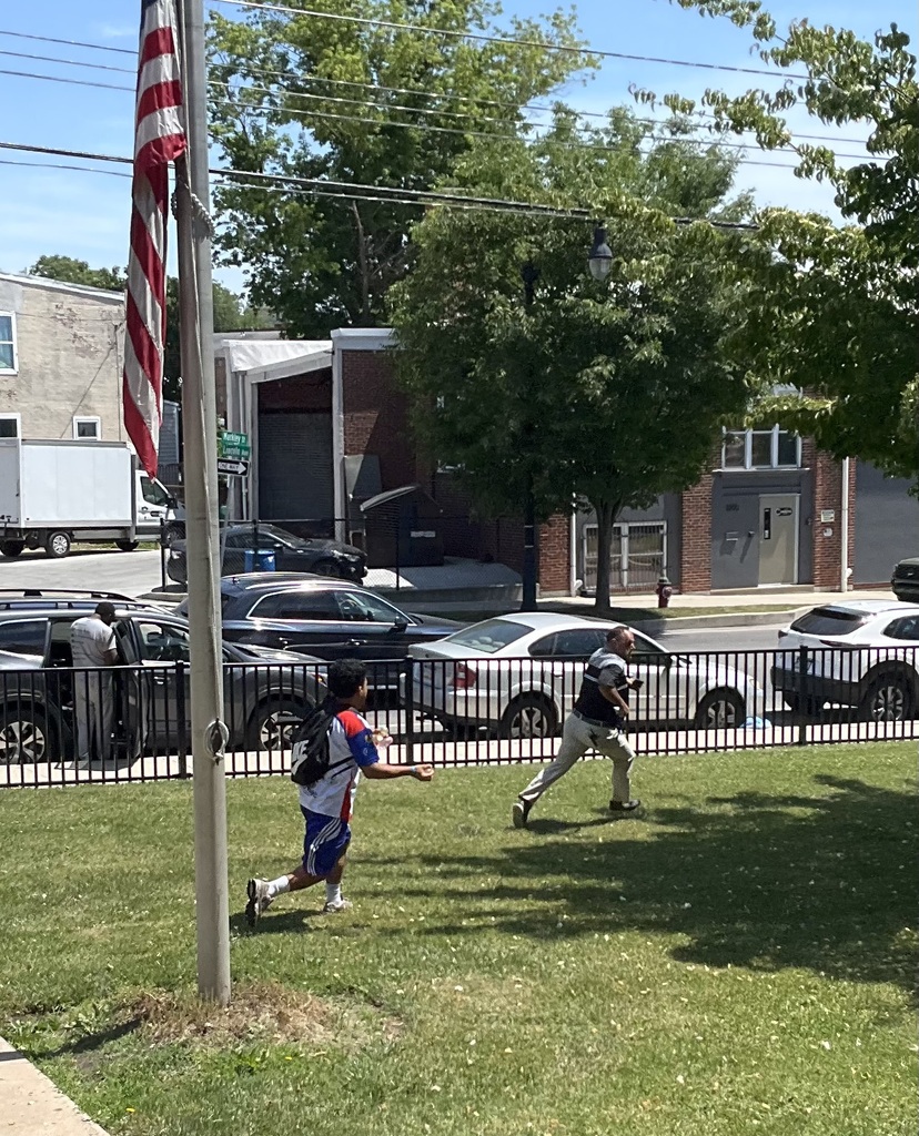 The principal is being chased by water balloons with a student