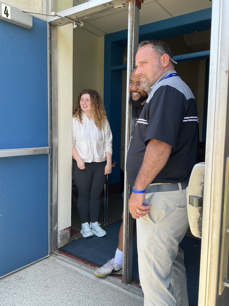 Three staff members are watching from the door way