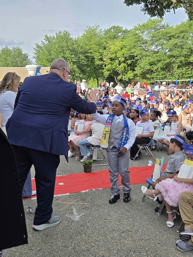 Mr. Dormer, Superintendent, high fives a student.